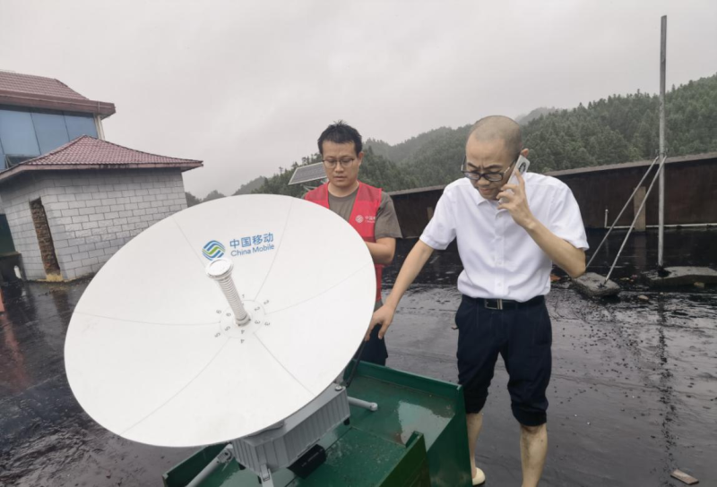 图为湖南移动网络抢修突击队员在受灾最严重的州门司紧急开通卫星基站。