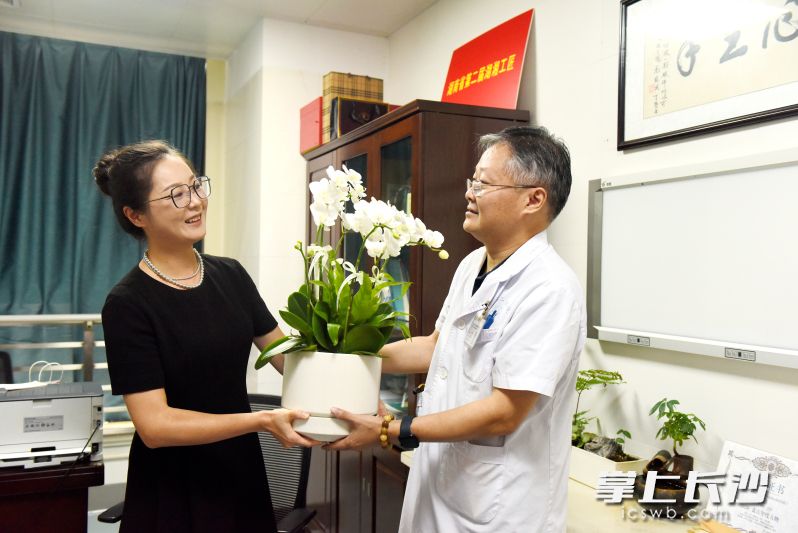 陈娟将蝴蝶兰送给唐浩主任医师及医护团队。