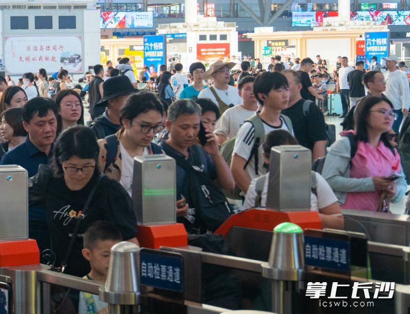 暑运期间，在长沙火车南站，旅客们检票准备乘车。