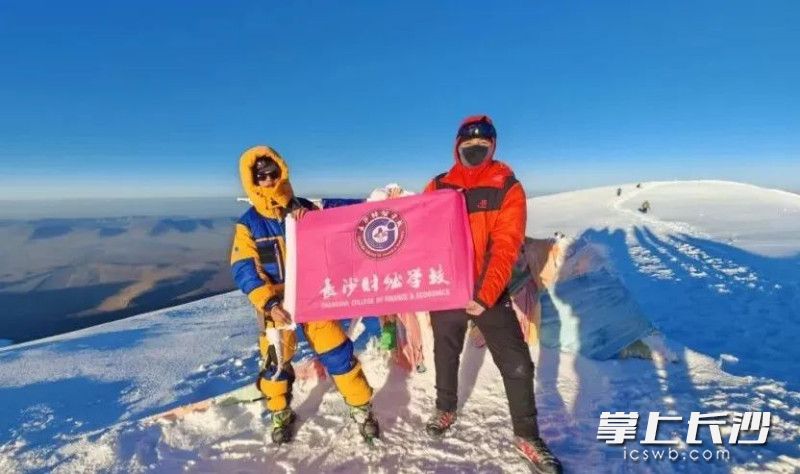 在海拔6178米的昆仑东段最高峰玉珠峰上，朱浩宇（左一）和队友手持长沙财经学校的校旗。照片由本人提供。
