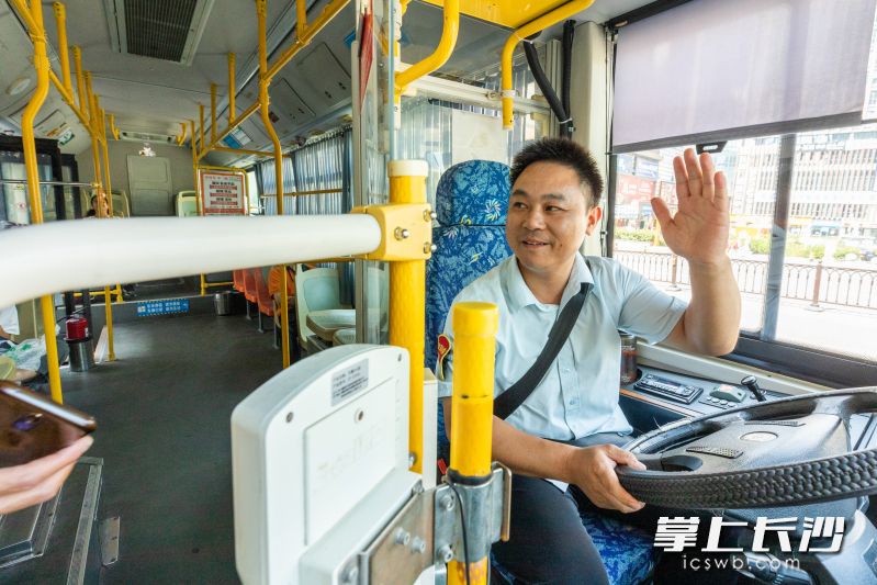 刘洋对上车乘客打招呼并提供微笑服务。 长沙晚报全媒体记者 董阳 摄