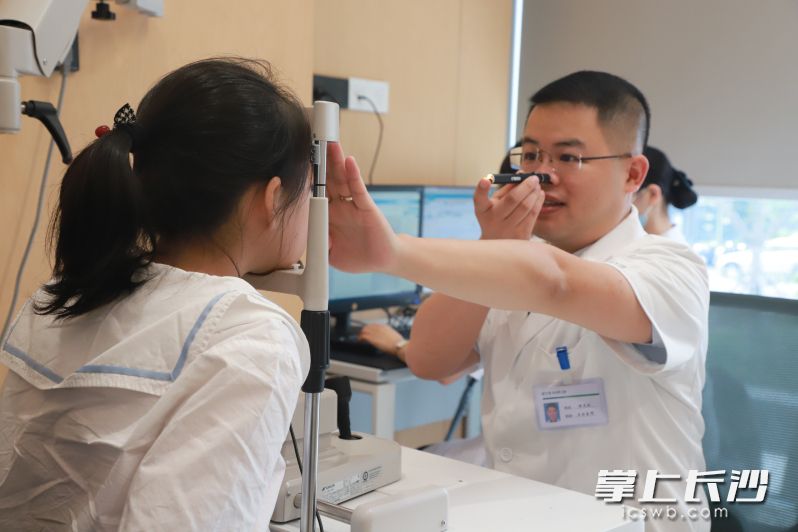 开学前，不少家长带着孩子来到长沙爱尔眼科医院儿童眼科中心做视力检查，温龙波（右）正在为孩子检查视力。 均为通讯员供图