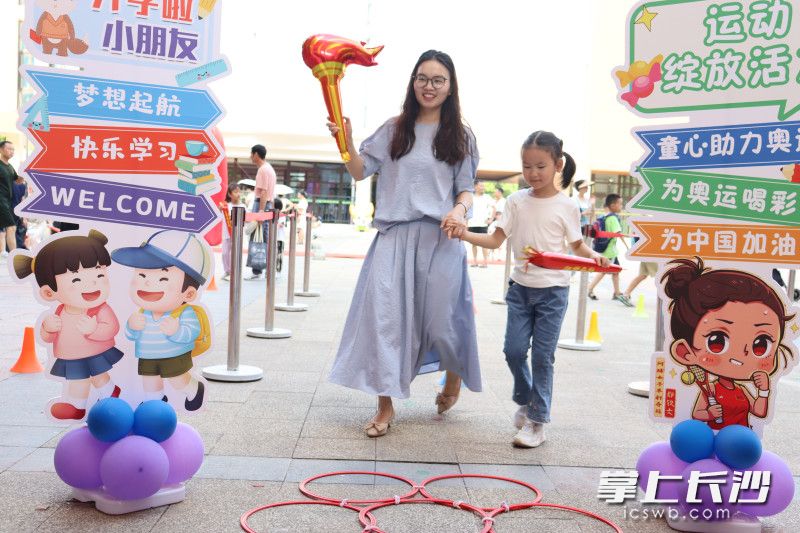 “启小新”们十分自豪地和爸爸妈妈一起打卡纪念。