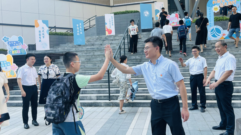 校领导在校门口迎接同学们的到来。