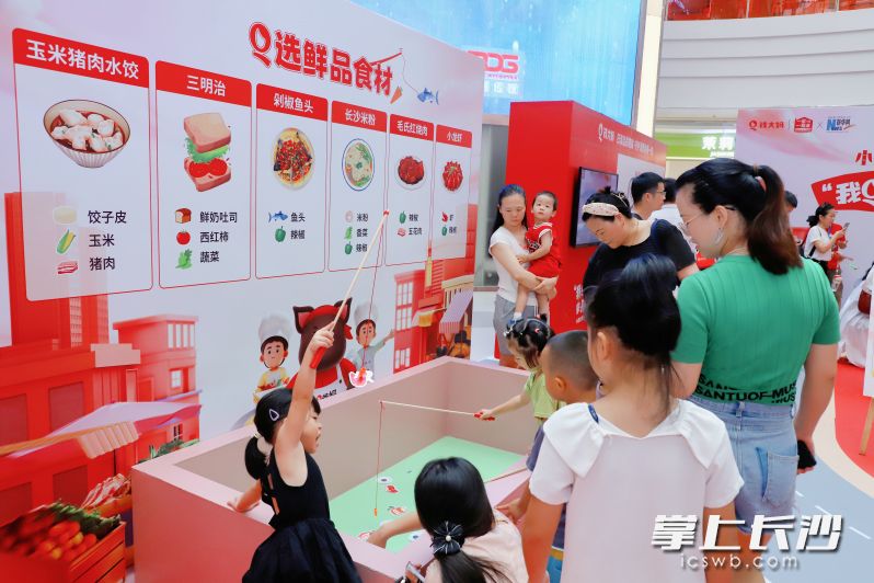 小朋友在“Q选鲜品食材”活动区参与长沙特色食材的搭配互动游戏。