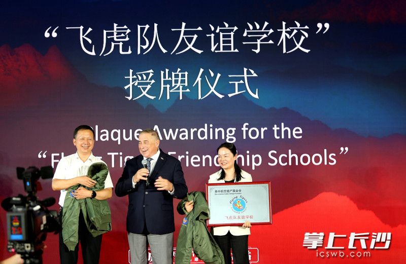麓山国际实验学校党委书记向雄海（左一）、校长杨革非（右一）接受美中航空遗产基金会主席格林赠予学校的飞虎队同款飞行夹克。 均为长沙晚报全媒体记者贺文兵摄