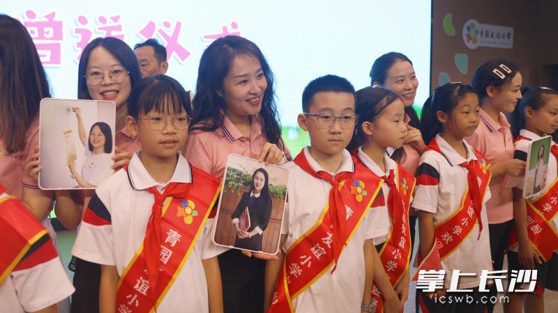 天心区青园友谊小学的教师们拿到照片后，开心地展示照片。