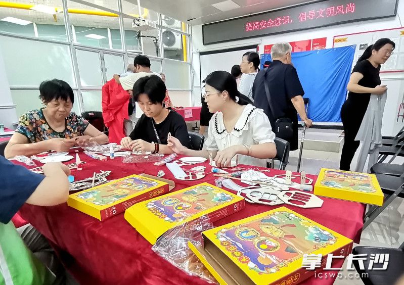 居民在一起制作手工月饼盒。