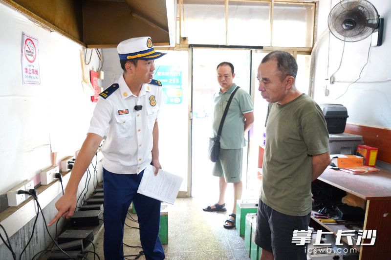 岳麓大队防火监督员在跟门店老板讲述排插电池同时在门店内充电的危害。通讯员供图