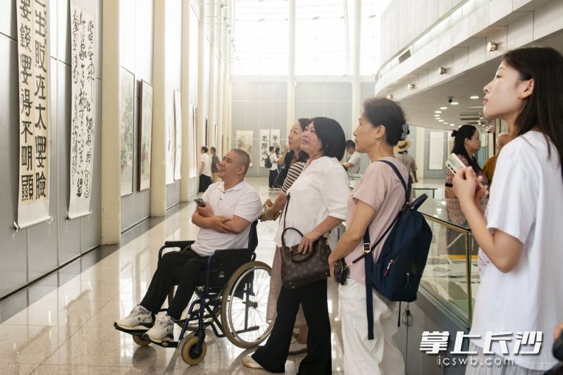 现场观众正在仔细品赏曹隽平书法作品。  长沙晚报通讯员 陈琛 摄
