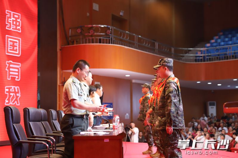 军地领导联合向新兵代表赠送红色书籍。 通讯员供图