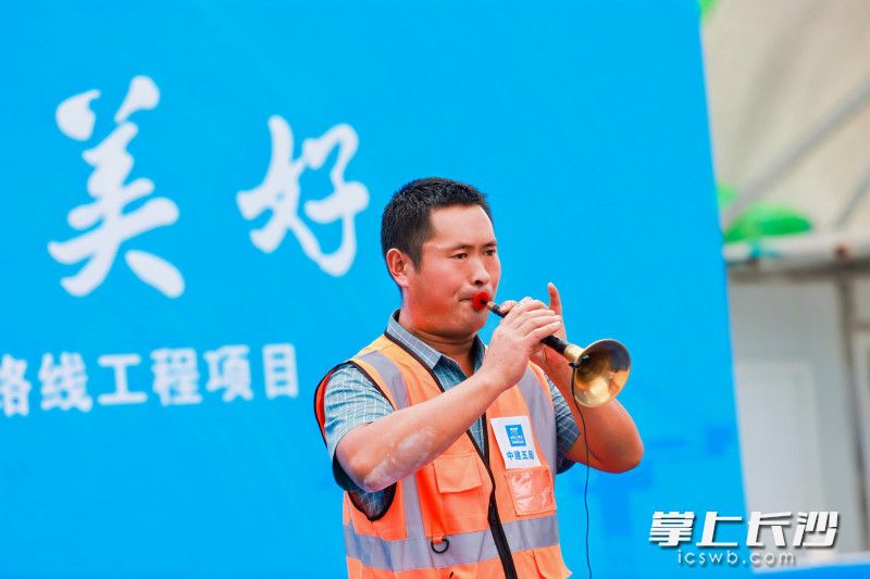 罗小虎正在表演吹唢呐。