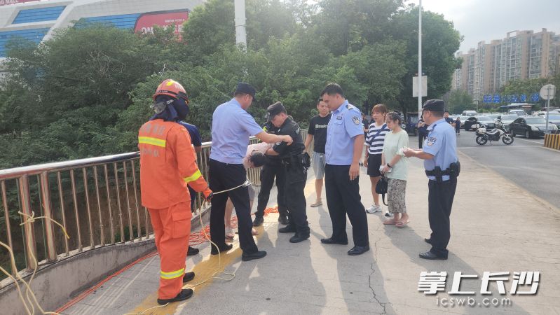 在众人的合力救援下,轻生男子被成功救了上来。 在众人的合力救援下,轻生男子被成功救了上来。