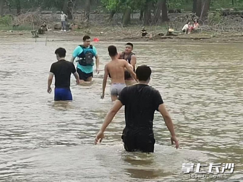 魏昊（蓝衣）和同伴们冲进水里救出溺水男子。 通讯员供图