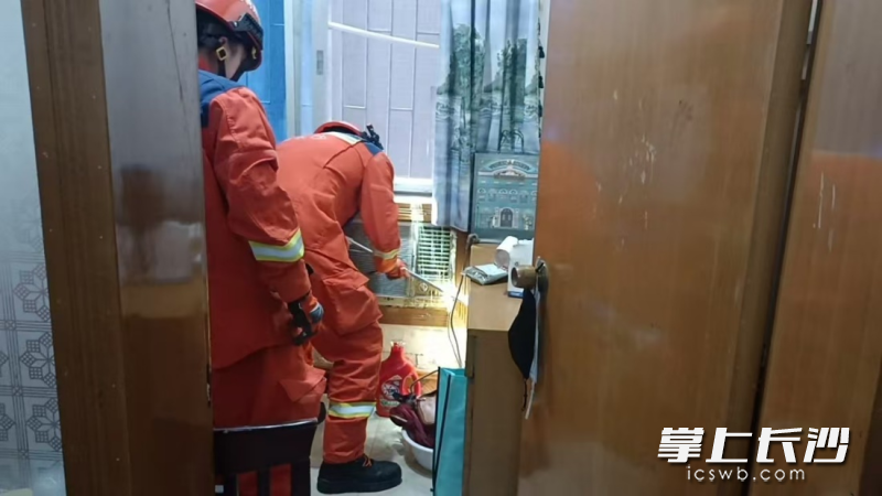 消防队员在房间仔细搜寻，最终发现是一场虚惊。长沙晚报通讯员供图