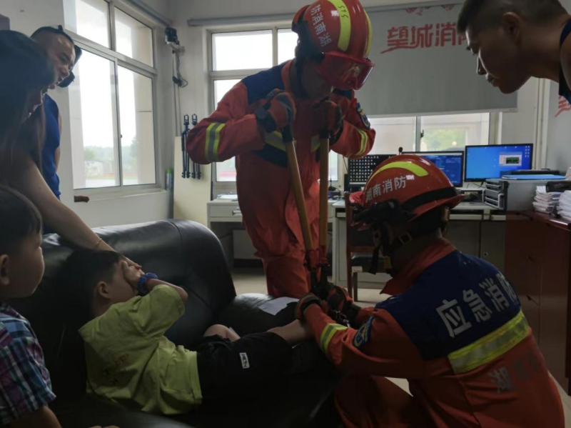 图为消防救援人员为被“铐”小男孩“解套”。长沙晚报通讯员供图