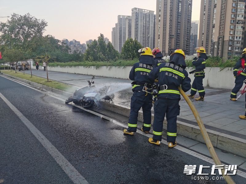图为消防队员为冒烟的电动摩托车冷却降温。长沙晚报通讯员供图