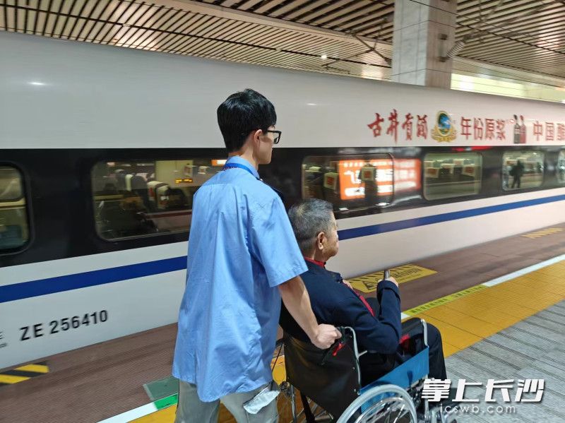 谭毅为老年旅客提供轮椅服务。