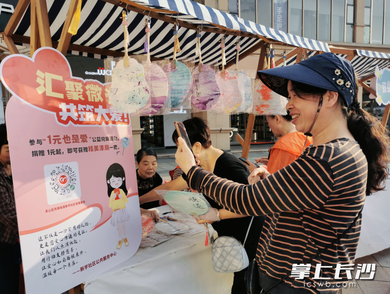 重阳沉浸式体验区，居民扫码领取公益漆扇。