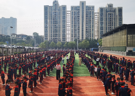 博才卓越小学东校区足球场,五年级少先队员为二年级新队员系上红领巾。 博才卓越小学东校区足球场,五年级少先队员为二年级新队员系上红领巾。