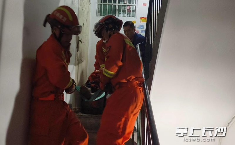 消防队员用担架送发病老人就医。长沙晚报通讯员供图