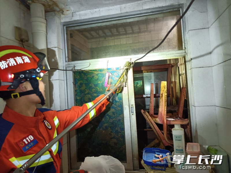消防队员将“入侵”居民家的大蛇捕获。 长沙晚报通讯员供图
