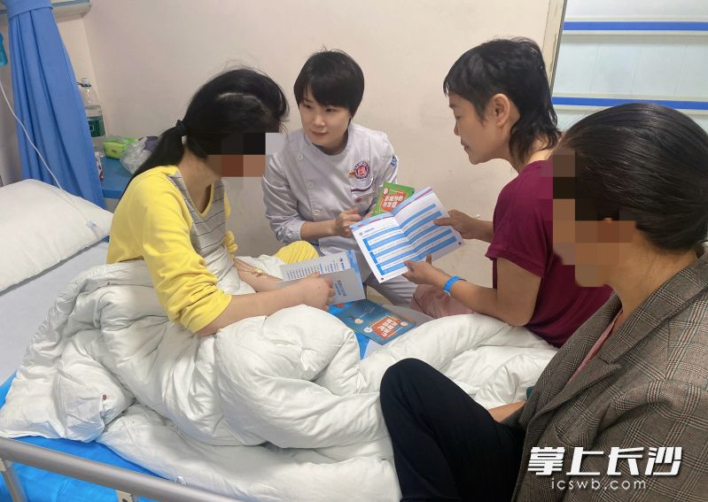 彭晶晶护士长和患者周姐给37床女孩做心理疏导。