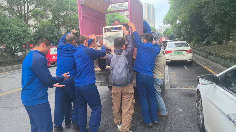 众人合力将三轮车抬上货车装运。 长沙晚报通讯员供图