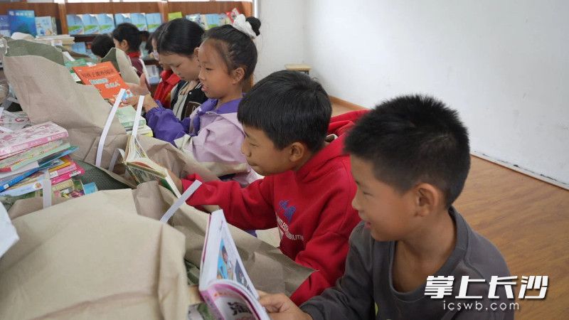 孩子们迫不及待地翻开书本阅读。 均为长沙福彩供图