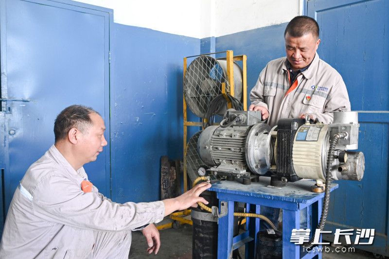 贺恒光（右）和刘泽鑫（左）调试自主研制的“空气压缩机联轴器试验台”。长沙晚报通讯员 雷彦怡 摄