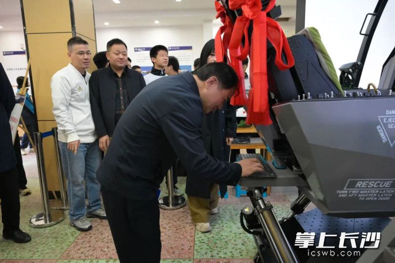 长郡中学校长邓智刚接过操作手册并输入密码，开启飞行设备。