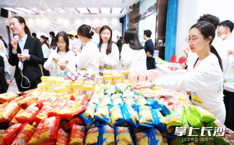 盐津铺子摆出各式各样的休闲零食款待来参观的大学生们。