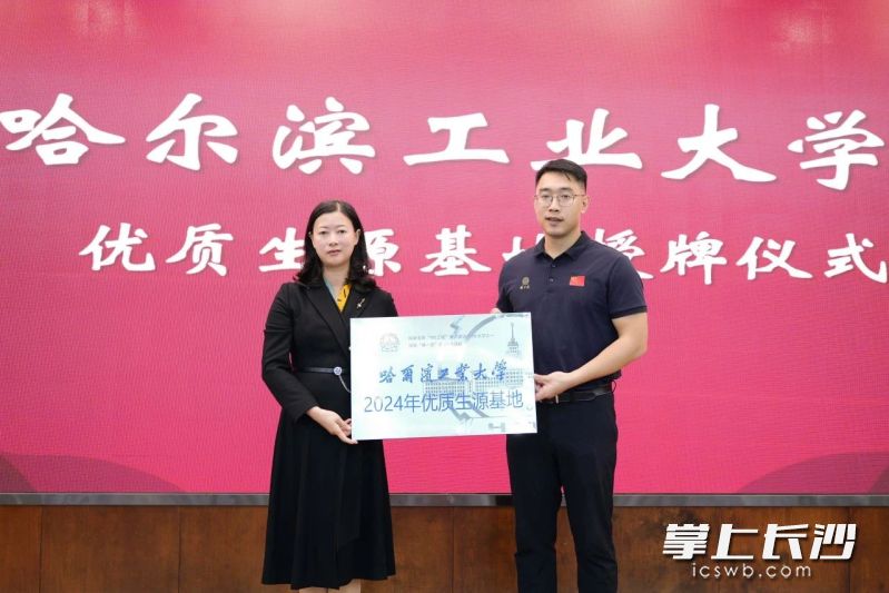 俞建阳教授（右一）向长沙市实验中学授牌“2024年优质生源基地”，长沙市实验中学校长张桃（左一）代表学校接过牌匾。