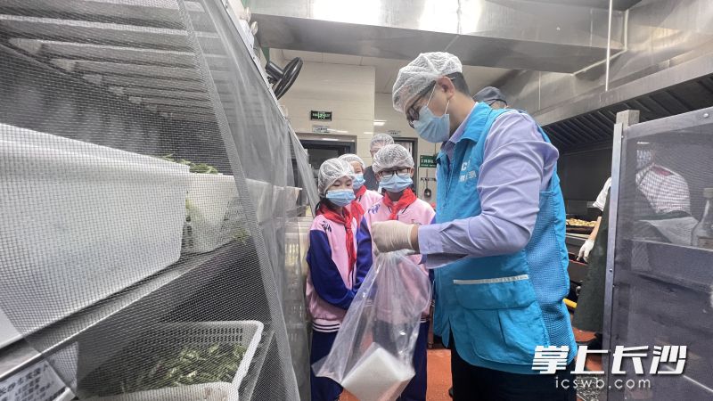 抽检人员根据学生代表的要求，对指定食材进行取样。照片均为长沙晚报全媒体记者 周辉霞 摄