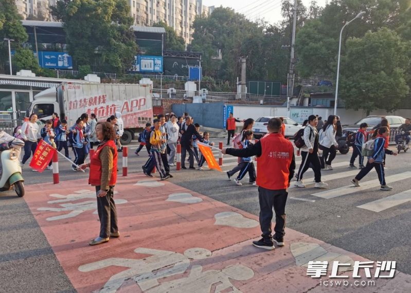 志愿者在沿线100米认真护送孩子过马路