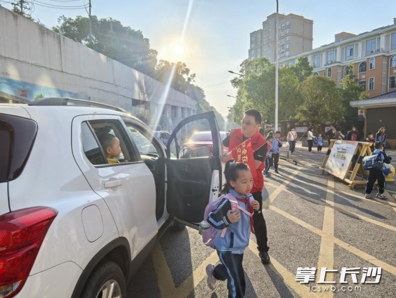 志愿者引导接送孩子的家长车辆即停即走。 均为 全媒体记者 吴鑫矾 通讯员 曹晓祎 谭昕 摄