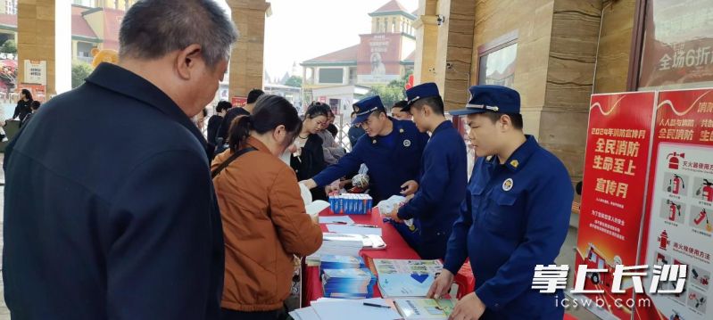 消防宣传员向市民发放消防宣传资料。 消防宣传员向市民发放消防宣传资料。