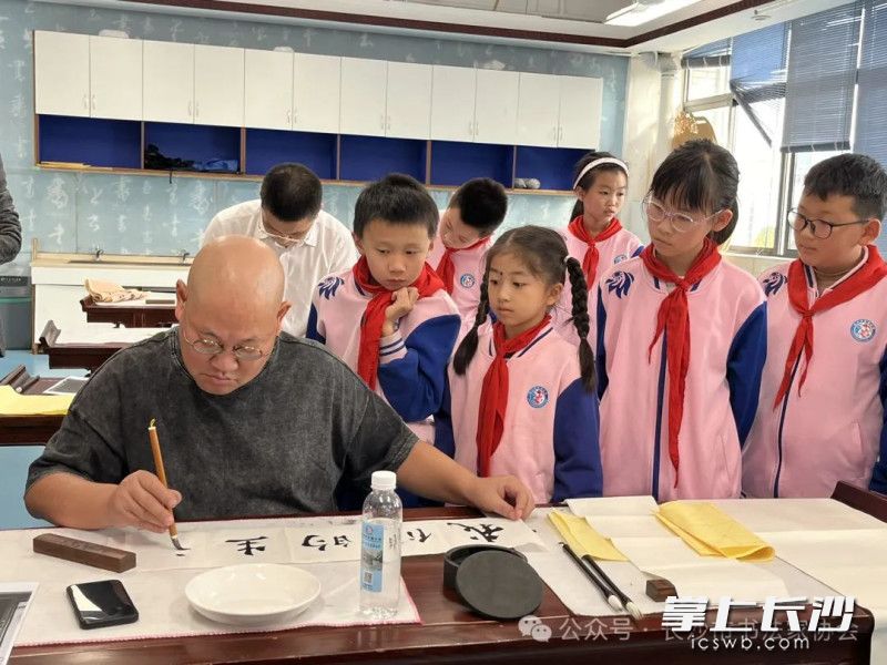 书法家现场创作，孩子们认真观赏学习。