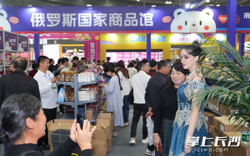 俄罗斯国家商品馆内，观展市民和美丽大方的俄罗斯工作人员合影。长沙晚报全媒体记者 邹麟 摄