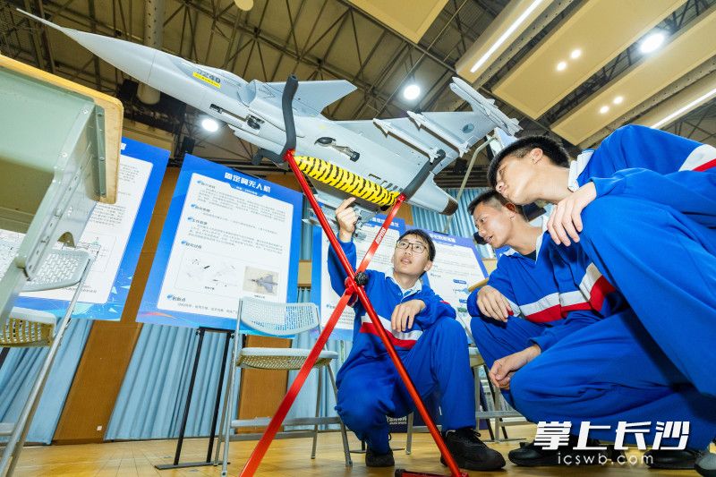 长沙市雅礼书院中学学生在讨论发明创新作品（固定翼无人机）。