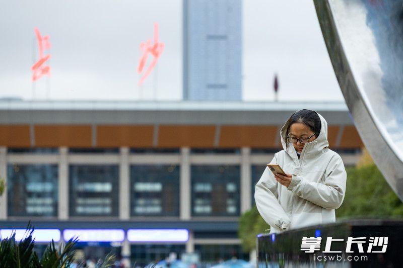 11月17日，长沙火车站东广场，一女士戴帽缩袖抵御冷风。均为长沙晚报全媒体记者 董阳 摄