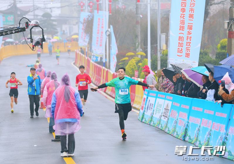 一名选手在即将抵达终点时，兴奋地张开双臂庆祝。 均为长沙晚报全媒体记者颜开云摄
