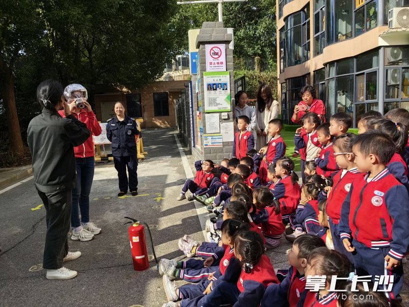 幼师们和孩子们学习正确佩戴防烟面罩的方法。
