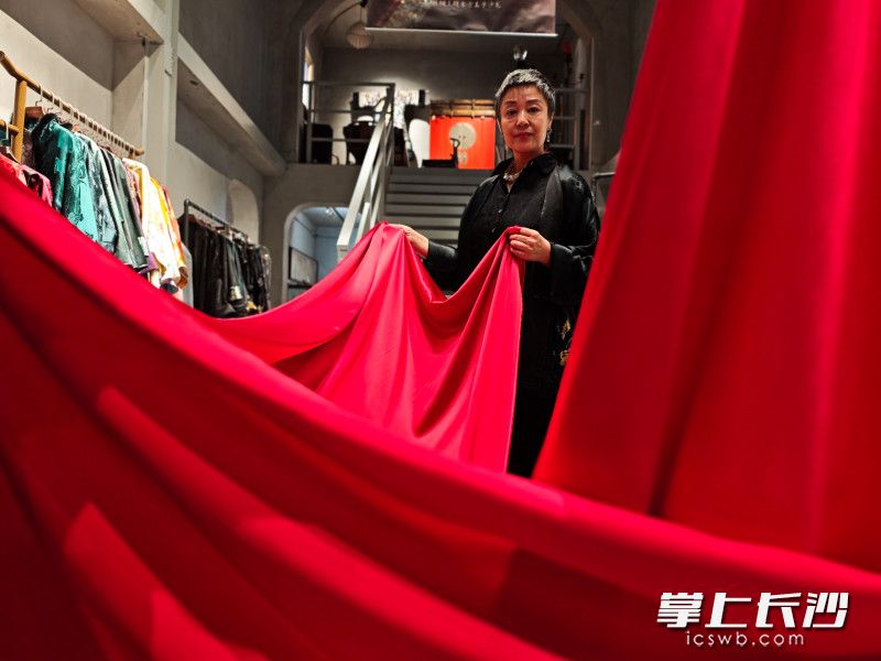 刘珂言为客人展示丝绸布匹。她说丝绸原本就是中国人的奢侈品，并不是只有国外才能有奢侈品。