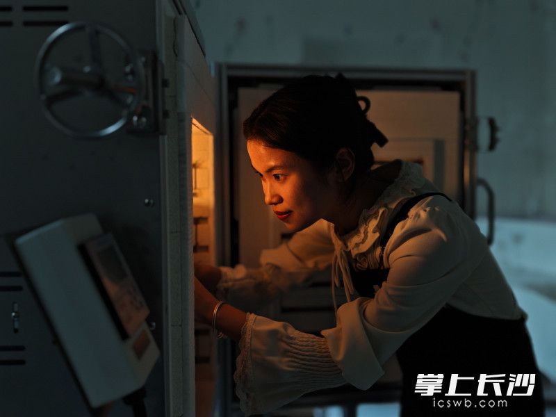 雷雨晴将加工好的灯工玻璃作品放入锅炉中加热。
