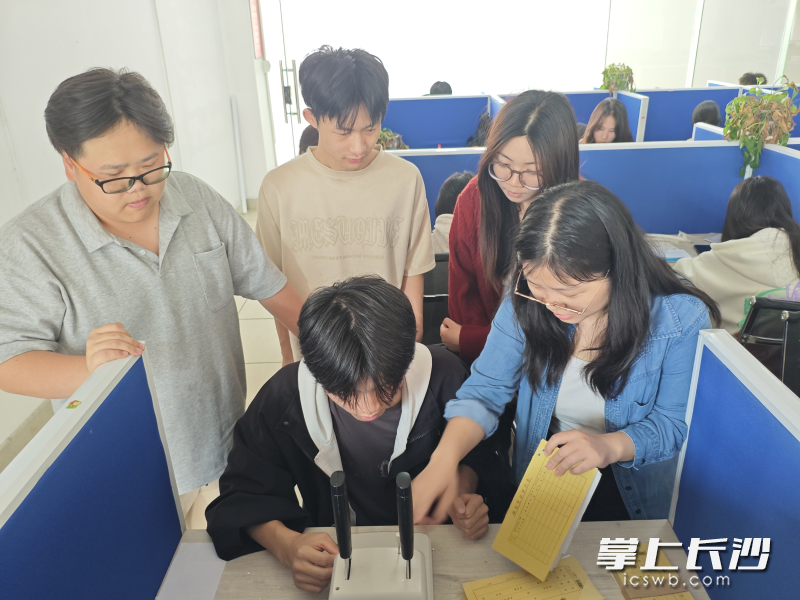 每个学生都安排了工位，模拟真实职场环境，图为学生在练习装订凭证。长沙晚报通讯员 李裕展 供图