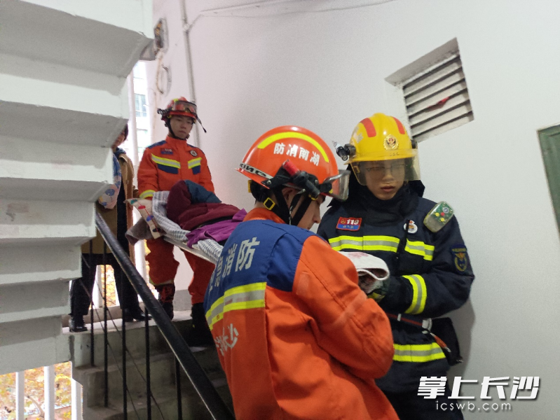 消防员将被困家中老人救出送医。 长沙晚报通讯员 李斌 摄