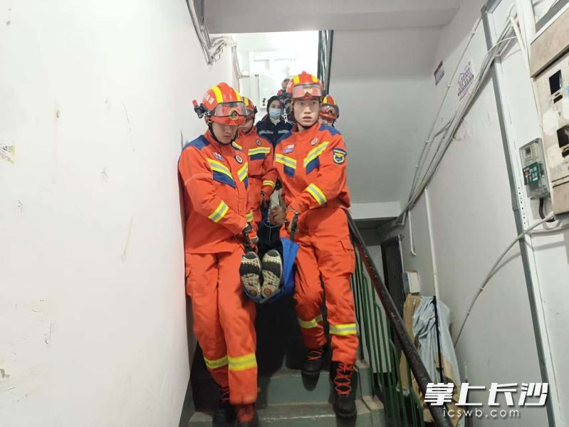 消防队员将深夜发病的老人抬下楼送医。 长沙晚报通讯员 李斌 摄