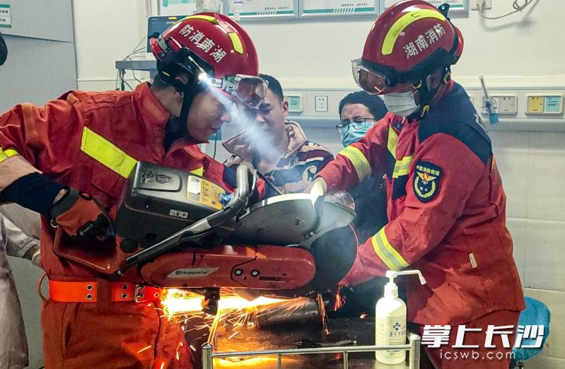 消防员用工具对绞肉机进行破拆。 长沙晚报通讯员 周雷 摄