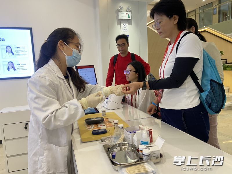 参观者在位于长沙的三诺生物总部体验血糖检测。长沙晚报全媒体记者 周斌 摄